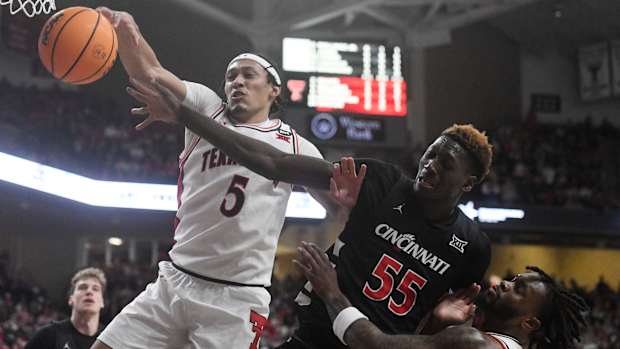 Texas Tech's guard Darrion Williams (5) and Cincinnati's forward Aziz Bandaogo (55) reach for the ball during the Big 12 basketball game, Saturday, Feb. 3, 2024, at United Supermarkets Arena.